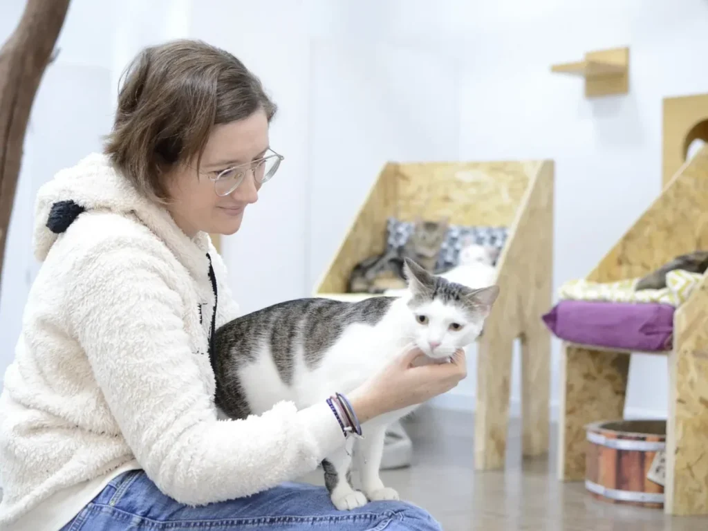 La Meri, una catsitter acaronant un gat